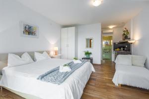 a bedroom with a large white bed and a couch at Apartments Zomzi in Poreč
