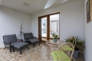 a room with two chairs and a table and a mirror at Apartments Zomzi in Poreč