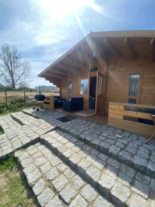 a house with a stone patio in front of it at Domek przy Róży in Ostromice