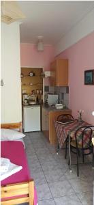 kuchnia i jadalnia ze stołem i krzesłami w obiekcie Sunny Room Lefkada w mieście Ligia