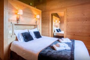 a bedroom with a large bed with towels on it at Chalet Flocon Magique - OVO Network in Saint-Jean-de-Sixt