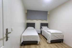 two beds in a hospital room with a window at Lamartin in Istanbul