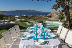 ein Tisch mit blauen und weißen Gerichten darauf in der Unterkunft Villa Cava Del Tom Luxury in Porto Rotondo