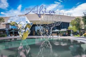 a fountain in the middle of a pool in front of a building at Keza Cove at Waterfall Ellipse in Midrand