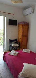 a bedroom with two beds with red sheets and a window at Sunny Room Lefkada in Lygia
