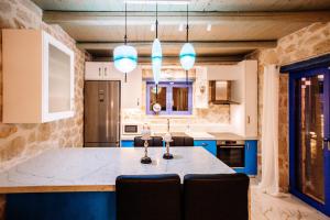 a kitchen with a table and chairs in it at Villa Rosemarie - Luxurious Villa with Pool Just Steps Away from the Sea By Villa Mana Gers in Psarou