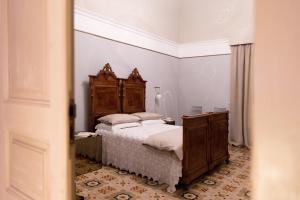 a bedroom with a bed with a wooden headboard at 206 Via Roma in Linguaglossa