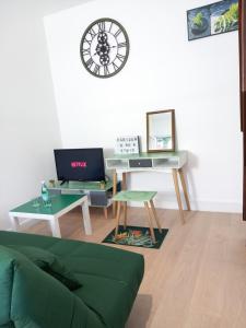 uma sala de estar com um sofá e um relógio na parede em Pari57bis - T2 meublés entre centre ville et Futuroscope à 15min - CHU - CCI à 5 min em Poitiers