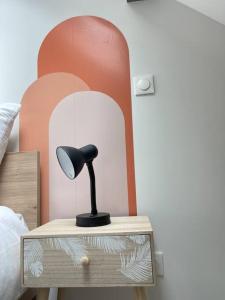 a black lamp on a table in a bedroom at La Bohème in Challuy