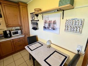 a kitchen with a counter and a table in it at Top ausgestattete Ferienwohnung in Stinteck nahe Büsum in Westerdeichstrich