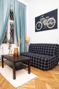 Kolibri Central Apartment في بودابست: غرفة معيشة مع أريكة وطاولة