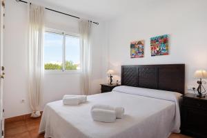 a bedroom with two beds with white sheets and a window at Apartamento Sancti Petri in Chiclana de la Frontera +18 photos