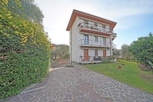 una casa grande con una pasarela de piedra delante de ella en Casa Pelèr - Gardagate, en Toscolano Maderno