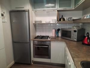a kitchen with a stove and a refrigerator at Villa in the Village in Johannesburg