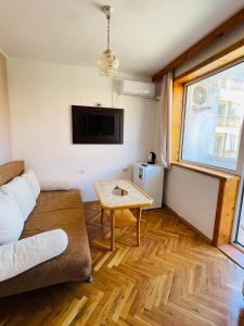 a living room with a couch and a table at Private Rooms Trakiets in Pomorie
