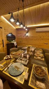 een houten tafel met veel borden eten erop bij Toriiana Chalet in Ash Sharāʼi‘ al ‘Ulyā