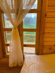 een slaapkamer met een raam met een bed en een gordijn bij Toriiana Chalet in Ash Sharāʼi‘ al ‘Ulyā