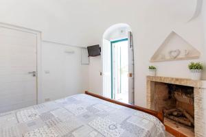 een witte slaapkamer met een bed en een open haard bij La Quercia in Selva di Fasano