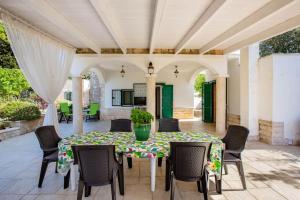 een patio met een tafel en stoelen bij La Quercia in Selva di Fasano