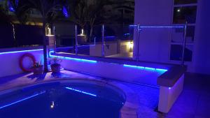 a house with a swimming pool with blue lights at Monalysa St Honore Apartment & Studios Grand Bay in Grand-Baie