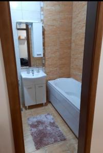 een badkamer met een wit bad en een wastafel bij Apartman Dionis Centar in Trebinje
