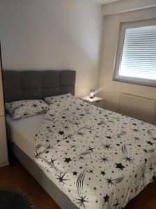 een slaapkamer met een bed met een dekbed met sterren bij Apartman Dionis Centar in Trebinje