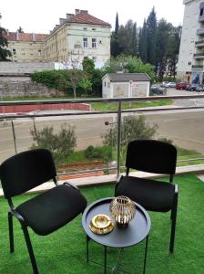 2 stoelen en een tafel op een balkon met uitzicht bij Apartman Dionis Centar in Trebinje
