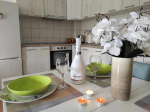 een keuken met een tafel met een fles wijn en glazen bij Apartman Dionis Centar in Trebinje