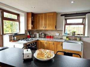 a kitchen with a table with a plate of food on it at LYDONIA BARN in Lydford