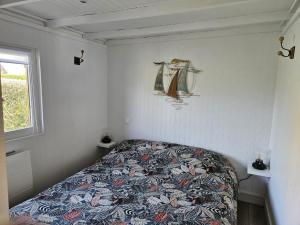 a bedroom with a bed with a quilt on it at Charmant chalet 200 m de la mer in Merville-Franceville-Plage