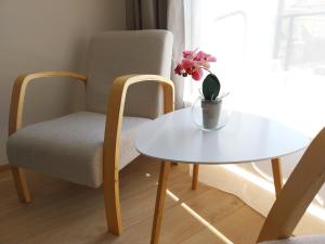 una mesa blanca y una silla y una mesa con una flor. en Aisa Apartment, en Pärnu
