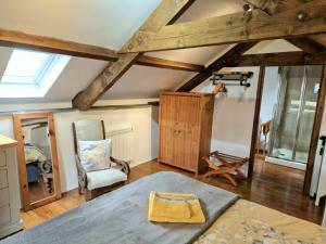 a bedroom with a bed and a chair in a room at LYDONIA BARN in Lydford