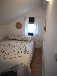 een slaapkamer met een bed met een dekbed en een raam bij Apartman Snežana Jugovo in Smederevo