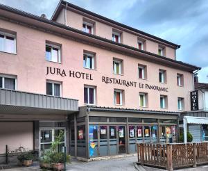 een jumeirah hotel met een roze gebouw bij Jura Hotel Restaurant Le Panoramic in Saint-Claude