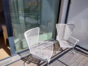 tres sillas de mimbre sentadas en la parte superior de un porche en Aisa Apartment, en Pärnu