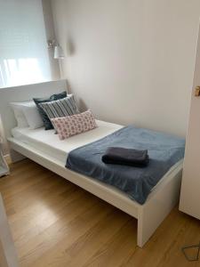białe łóżko z niebieskim kocem i poduszkami w obiekcie Apartamento Vallecas Plaza w Madrycie