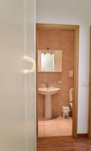 bagno con lavandino, specchio e servizi igienici di Civico 18- La tua casa in centro a Latina