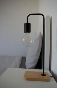 una lámpara sentada en una mesa junto a una cama en Civico 18- La tua casa in centro en Latina