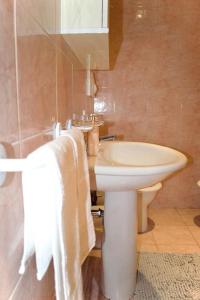bagno con lavandino bianco e servizi igienici di Civico 18- La tua casa in centro a Latina