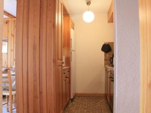 einen Flur einer Küche mit einem Kühlschrank und einem Tisch in der Unterkunft Apartment Topaze 4 by Interhome in Villars-sur-Ollon