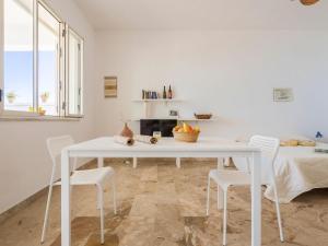 uma sala de jantar branca com uma mesa e cadeiras brancas em Studio Seccagrande by Interhome em Borgo Bonsignore