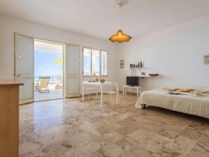 a white room with a bed and a table and a kitchen at Studio Seccagrande by Interhome in Borgo Bonsignore