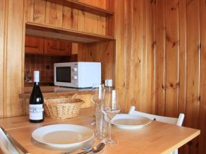 a table with two plates and a bottle of wine at Apartment Topaze 2 by Interhome in Villars-sur-Ollon