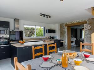 uma cozinha e sala de estar com mesa e cadeiras em Holiday Home Kernic Ty - PLC219 by Interhome em Plounévez-Lochrist