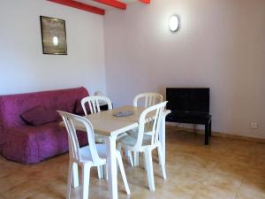 sala de estar con mesa, sillas y sofá en Apartment Cala di Sole - ALG131 by Interhome en Algajola