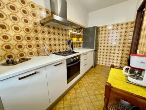 una cucina con armadi bianchi e piano cottura di Holiday Home Casa del Villaggio by Interhome a Baveno