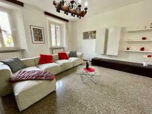 ein Wohnzimmer mit einem weißen Sofa und roten Kissen in der Unterkunft Holiday Home Casa del Villaggio by Interhome in Baveno