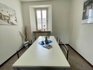 un tavolo bianco con sedie in una stanza di Holiday Home Casa del Villaggio by Interhome a Baveno