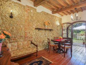a living room with a table and a stone wall at Apartment Fattoria Petraglia - Loggiato by Interhome in Monteriggioni