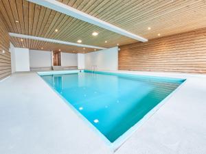 a swimming pool in a house with a wooden ceiling at Studio Le Hameau D002 by Interhome in Les Collons